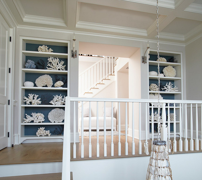 Built-in bookcases with wallpaper display a beautiful collection of white and blue corals. #Coral #bookcase #wallpaper TS Adams Studio Architects. Laura Allyson Interiors.