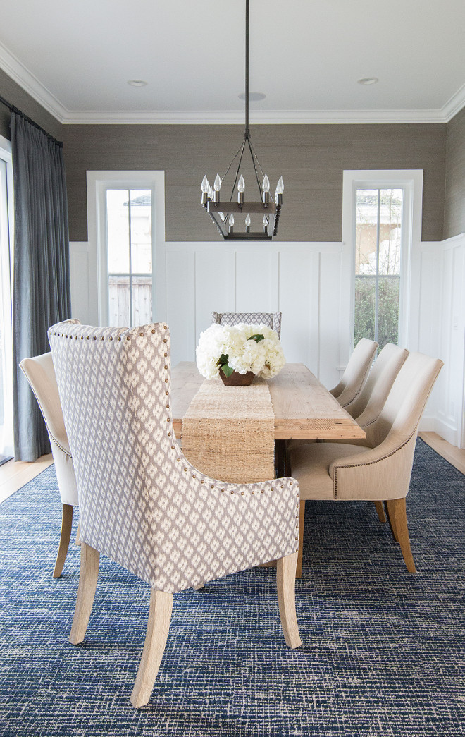 Dining room wainscoting. In this dining room, the designer added a slate blue gray grasscloth wallpaper above the wainscot that really adds an extra pop of color and richness to this room. #diningroom #wainscoting Blackband Design.