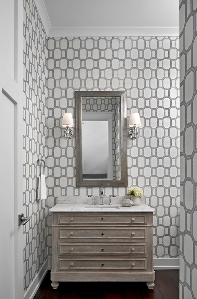 Geometric wallpaper. Geometric wallpaper Phillip Jeffries What a Gem Silver on White Manila Hemp wallpaper lines the walls of this stunning gray powder room boasting a French washstand topped with honed white marble countertops holding a sink fitted with a polished nickel faucet positioned under a gray beveled mirror flanked by polished nickel sconces, Jonathan 1 Light Sconces In Crystal with Natural Paper Shades. #geometric #wallpaper Marianne Jones LLC
