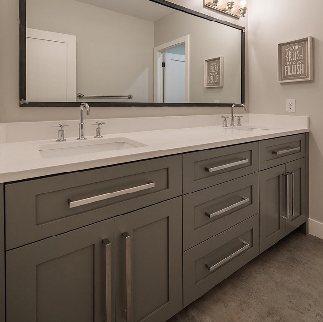 Grey bathroom cabinet with white quartz countertop and concrete floors. Northstar Builders, Inc.