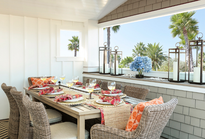 Outdoor dining area. How to decorate outdoor dining areas - furniture, tabletop, decor, rug. In this outdoor area, happy colors play beautifully against classic architectural elements such as shingles and board and batten walls. Designed by interior designer Barclay Butera.