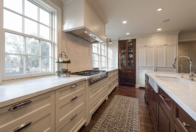 White kitchen cabinets with walnut kitchen island and oak floors. Northstar Builders, Inc.