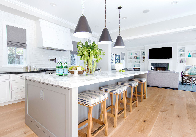 White kitchen with pale grey island and striped barstools. California style White kitchen with pale grey island and striped barstools. #Whitekitchen #palegreyisland #stripedbarstools Graystone Custom Builders. Blackband Design.