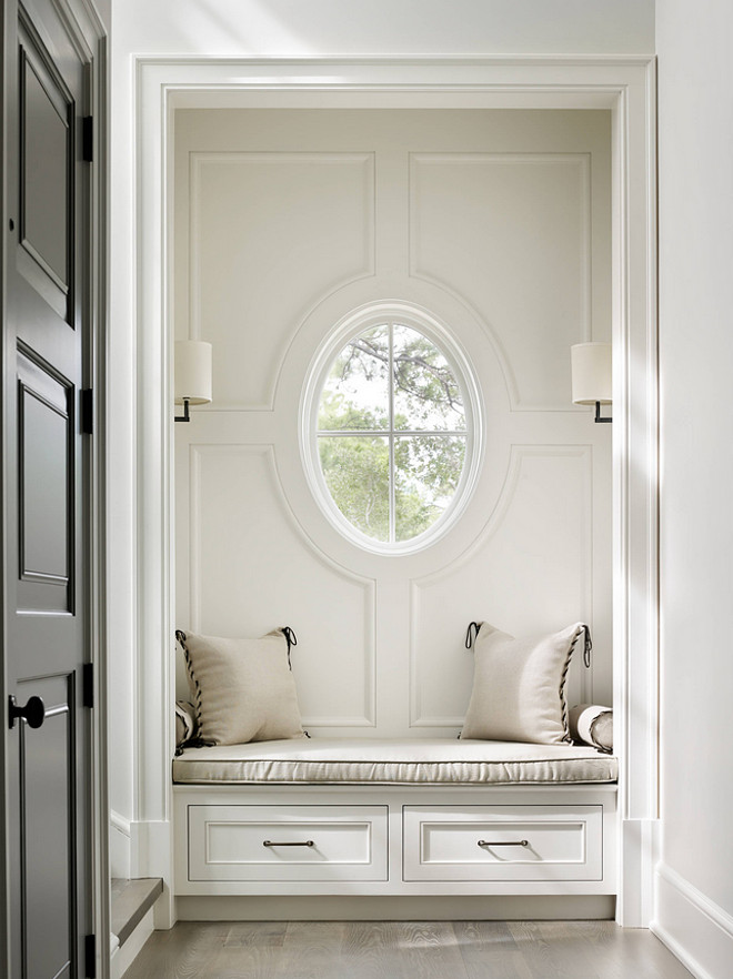 Benjamin Moore Sheeps Wool. Benjamin Moore Sheeps Wool. Foyer features a nook with a built-in window seat with drawers illuminated by Barbara Barry's sconces next to staircase and grey front door. Wall paint color is Benjamin Moore Sheeps Wool. #BenjaminMooreSheepsWool Beth Webb Interiors