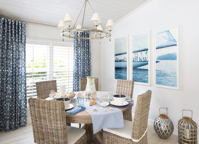 Dining area with rattan dining chairs, reclaimed wood ceiling, coastal wall art and navy draperies. #diningarea #rattanchairs #diningchairs ##woodceiling #reclaimedwoodceiling