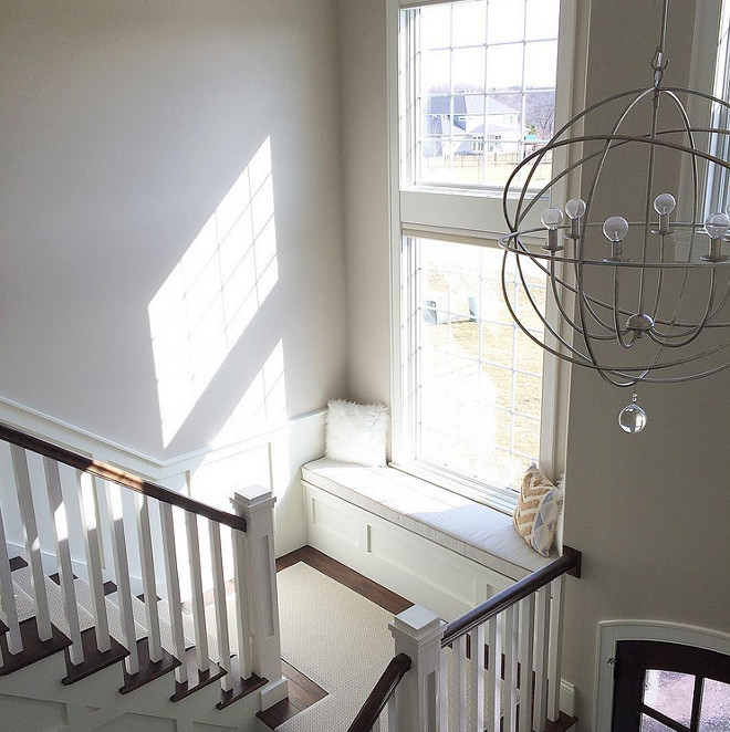 Foyer Orb lighting and stair window seat. Paint Color is Sherwin Williams SW7036 Accessible Beige. Orb chandelier in foyer. Orb chandelier is from Ballard Designs. #SherwinWilliams #SW7036 #AccessibleBeige Beautiful Homes of Instagram carolineondesign