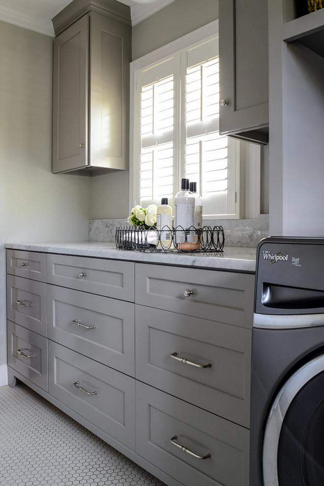 Laundry room Gray,cabinets, in,laundry,room, open,shelves,for, basket,storage,and,organization, organize,carrara,marble, counter, and,splash,hex,tile,floor,ceramic,vintage,look,ceiling,light. Laundry room with Carrara marble countertop. BRADSHAW DESIGNS LLC