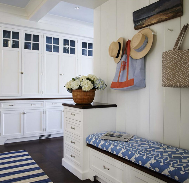 Mudroom. Classic coastal mudroom with white cabinets, blue and white bench fabric, shiplap walls and dark stained hardwood floors. Mudroom #Mudroom #Classiccoastal #coastalmudroom #whitecabinets #blueandwhite #bench #fabric #shiplap #darkstainedfloors #hardwoodfloors Lynn Morgan Design.