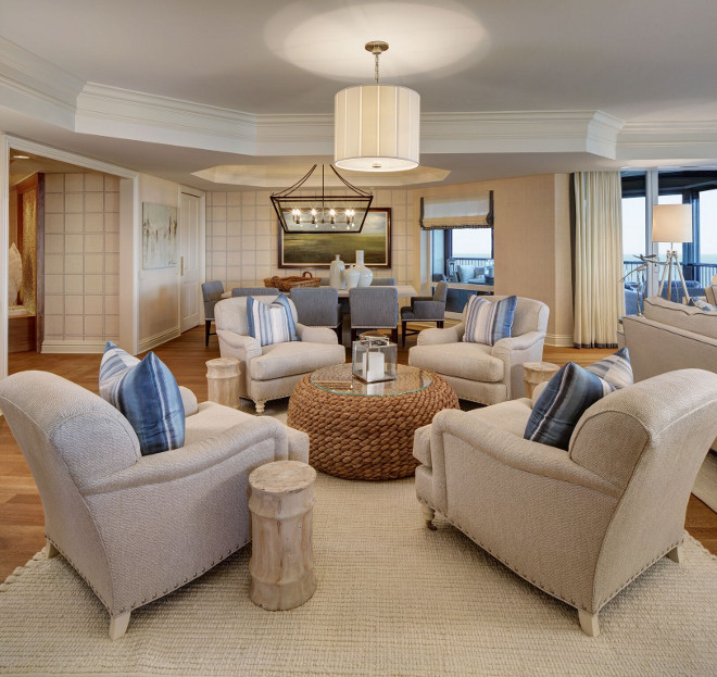 Round sitting area with four chairs and a round coffee table, Ralph Lauren woven seagrass table. Behind the sofas, you will find a round sitting area with four WHC cream colored arm chairs with blue striped throw pillows and a Ralph Lauren woven seagrass table. Four chairs sitting area in round sitting area with round woven coffee table #RalphLauren #woven #seagrass #Coffeetable #roundsittingarea #sittingarea W Design Interiors