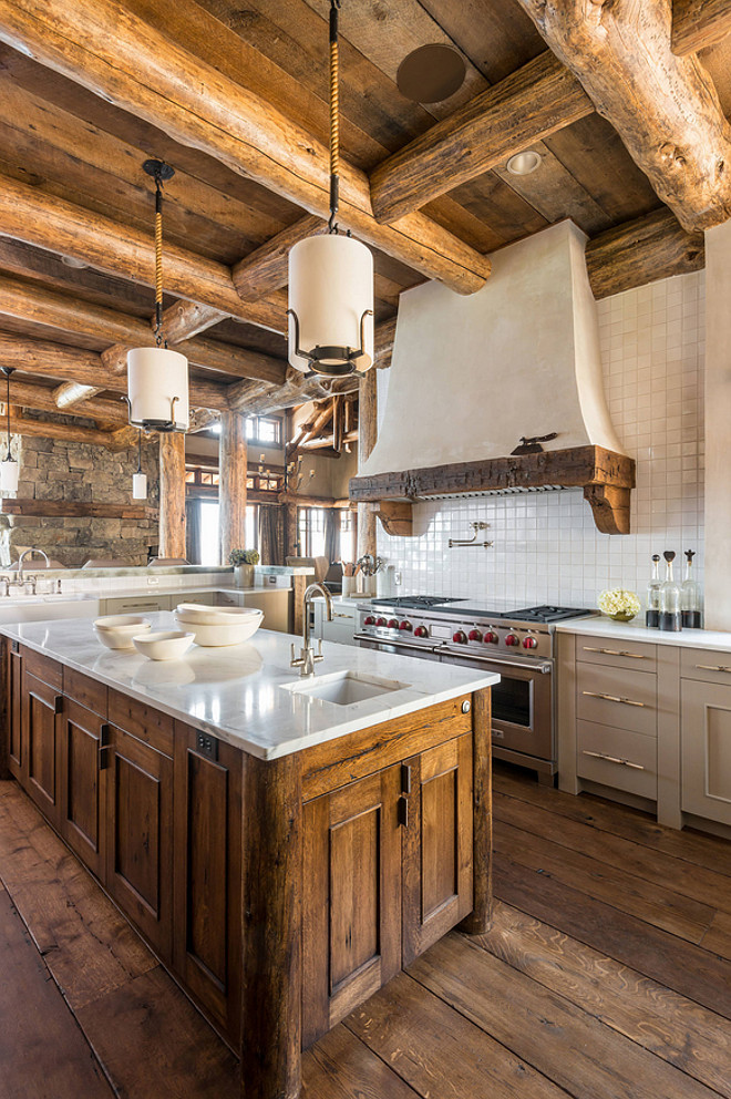 Rustic Kitchen. True Rustic Kitchen with rustic plank wood ceiling and rustic log ceiling beams, wide plank hardwood floors, reclaimed wood island with white marble, pale gray perimeter cabinets and rustic wood on kitchen hood. #RusticKitchen #RusticKitchen #rusticplankwood #plankwood #ceiling #usticlog #ceilingbeams #wideplank #hardwoodfloors #reclaimedwoodisland #whitemarble #cabinets Pearson Design Group