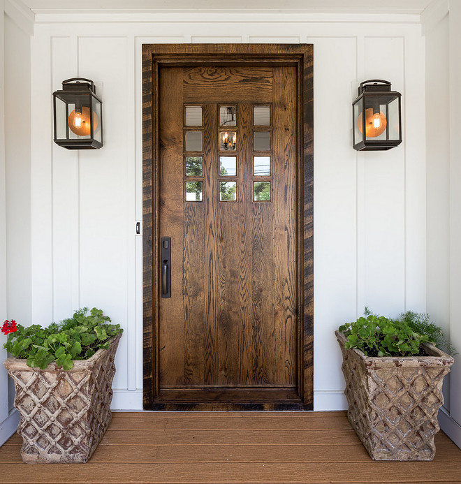 Farmhouse front door. White board and batten farmhouse exterior with wood front door. Farmhouse front door. Farmhouse wooden front door #Farmhouse #frontdoor #wooddoor #woodendoor #boardandbatten #homeexterior #entry J Taylor Designs