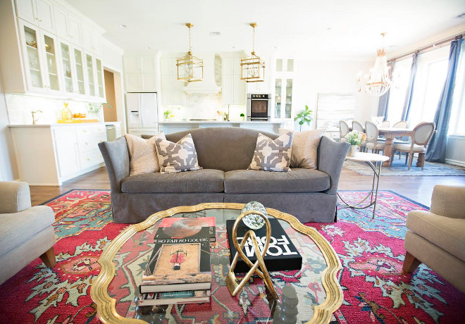 Grey sofa. This updated living space has a more colorful rug from Wayfair. The designer kept the two arm chairs in cream, but changed the old beige couch for a gray couch. The right side of the room features a sideboard from Gabby Home, that can be purchased through Ivy House. The art above was found at an estate sale and is the same art featured in the Master Bath. The ginger jars boxes and other accessories can also be purchased through Ivy House. The small accent table between the chairs is also from Gabby Home and can be purchased through Ivy House. grey-sofa #Greysofa #sofa Ivy House Interiors