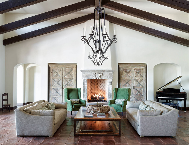 mediterranean-style-living-room-with-terracota-floor-tile-cathedral-ceilings-dark-stained-ceiling-beams-and-wrought-iron-lighting-the-refined-group