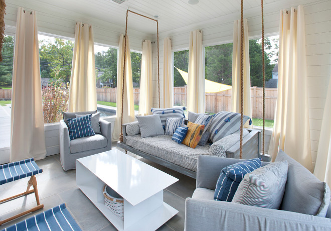 Screened-in porch featuring shiplap siding and ceiling, outdoor swing bed, heated flooring and interchangeable glass and screens, and access to the pool area. #screenedinporch #bedswing #shiplap #shiplapwalls #shiplapceiling Bluewater Home Builders