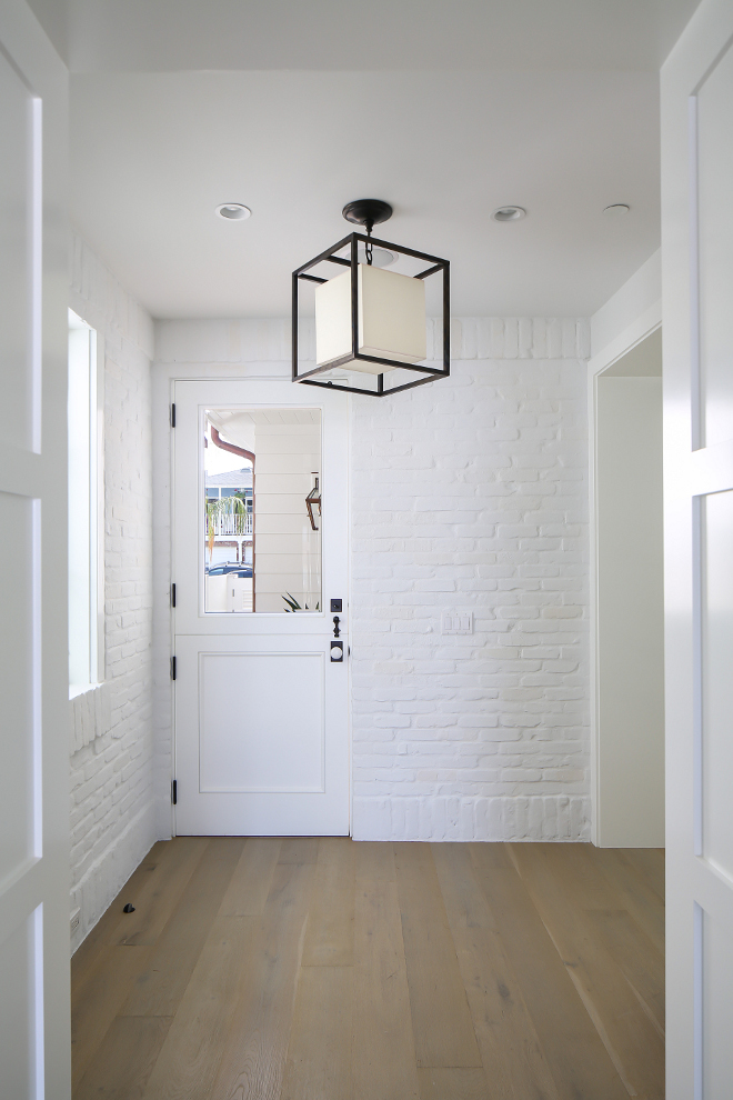 Painted Brick Mudroom. This mudroom, with painted white brick, is located just off the kitchen and features a Dutch door with glass. Lighting is Circa Lighting Caged lantern. Winkle Custom Homes. Melissa Morgan Design. Ryan Garvin Photography