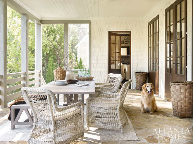 Porch. Back Porch. Elegant as any interior space, the porch is a study in natural materials and organic hues, creating a soft and serene scheme. A long, weathered teak table from Janus et Cie anchors the room. It is surrounded by comfortable woven armchairs by Kingsley-Bate. A teak dining bench, also by Janus et Cie, provides plenty of seating for friends and family. The rug is by Dash & Albert. The wicker demijohn is from A. Tyner Antiques. #BackPorch #porch #Porchtable #porchChairs #Porches #Backporches Beth Webb Via Atlanta Homes