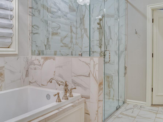 The tub and shower is set in a Calacatta Italian marble, which features gold and gray veins. the-master-bath-is-set-in-a-calacatta-italian-marble-which-features-gold-and-gray-veins Ivy House Interiors