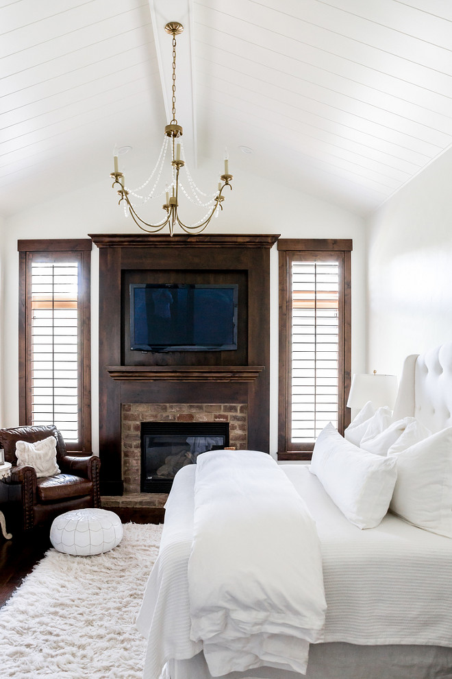 white-bedroom-with-white-shiplap-ceiling-dark-stained-trim-and-exposed-brick-fireplace