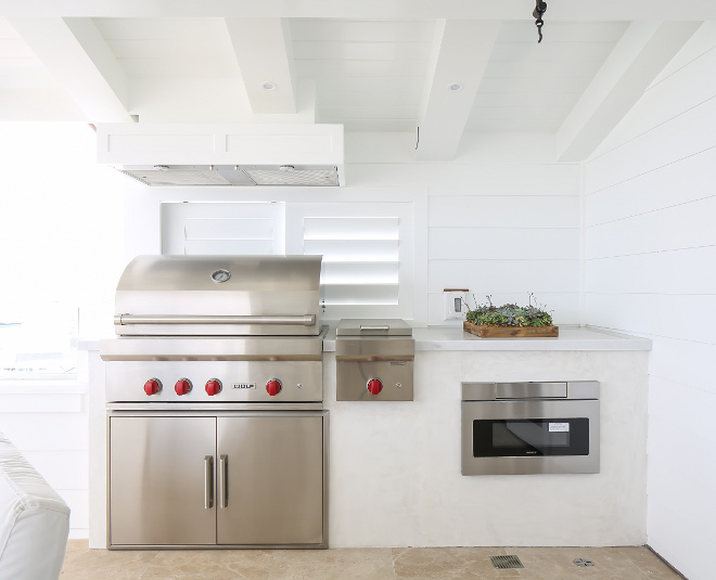 White outdoor kitchen. Grill is by Wolf. Microwave is by Sharp. #outdoorkitchen #grill #wolfgrill Winkle Custom Homes. Melissa Morgan Design. Ryan Garvin Photography