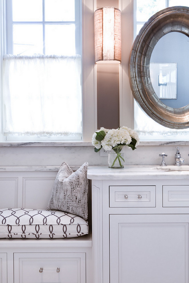 Bathroom window seat. Bathroom features window seat and white vanity. Bathroom vanity: white inset cabinetry with custom adjacent window bench seat. Fabric wall sconces, rustic oval mirror. Faucet is Jado Savina. bathroom-window-seat #Bathroomwindowseat #Bathroom #windowseat #bathroomwhitevanity #whitevanity #vanity Karr Bick Kitchen and Bath