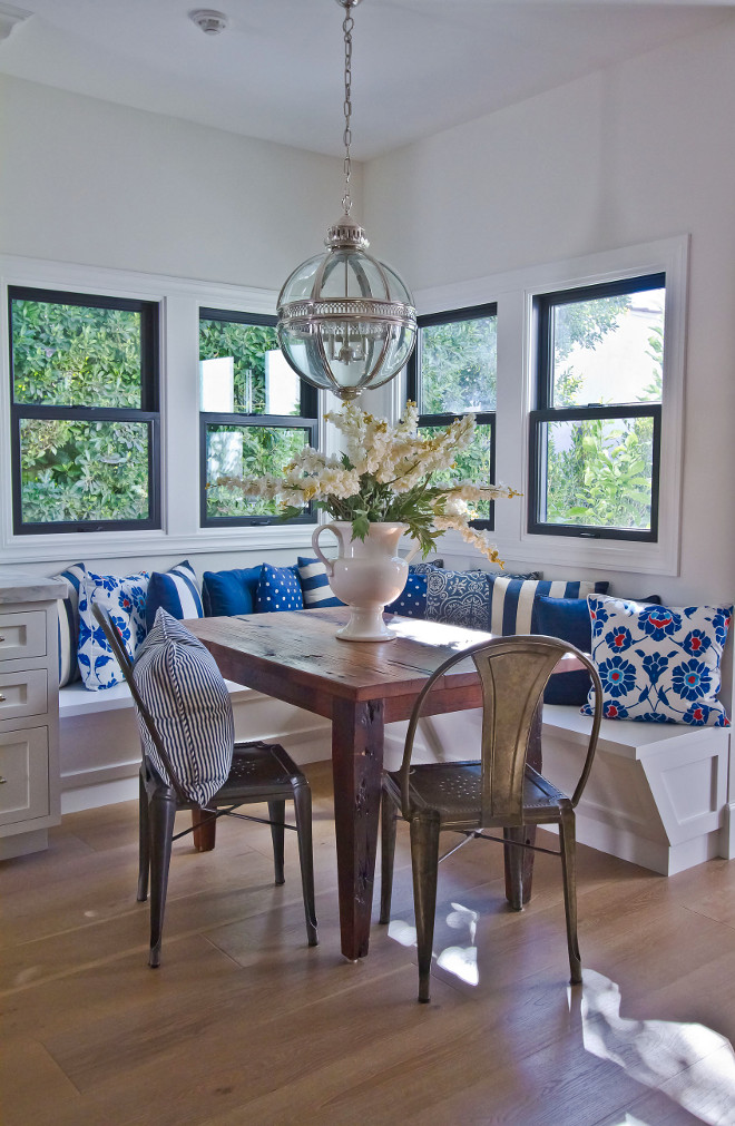 Breakfast room banquette. Breakfast room banquette features an antique farmhouse table, L-shaped banquette, blue and white pillows and black steel windows. The breakfast nook lighting is Restoration Hardware, Victorian Hotel Pendant. #breakfastroom #breakfastroombanquette #banquette #blueandwhite #banquetteideas #lshapedbanquette #lighting #farmhousetable breakfast-room-banquette Home Bunch Beautiful Homes of Instagram Bryan Shap @realbryansharp