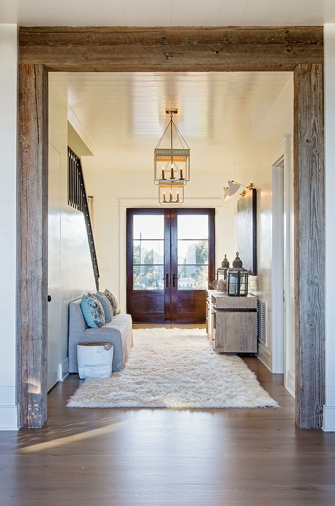 Beamed doorway. A reclaimed beamed doorway opens to main living areas of this beach house. #reclaimedbeams #beameddoorway #doorway #beams #reclaimedbeams Herlong & Associates Architects + Interiors