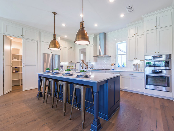 Kitchen with hidden walk-in pantry.. White kitchen with blue and island hidden walk in pantry cabinet. #Kitchen #hiddenpantry #walkinpantry #kitchenpantry kitchen-with-hidden-walk-in-pantry Cottage Home Company