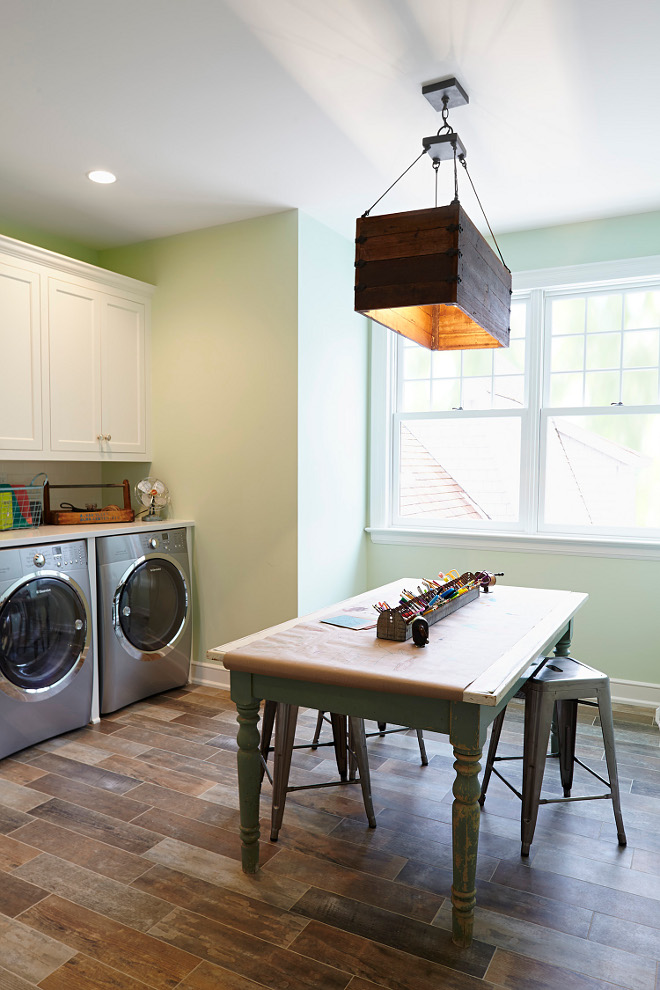 Benjamin Moore 2029-40 Stem Green. Laundry room and Craft room. This is such a functional space. Paint color is Benjamin Moore 2029-40 Stem Green. Lighting is from Currey and Co. Combination of laundry room and craft room. Benjamin Moore 2029-40 Stem Green #BenjaminMooreStemGreen #Laundryroom #Craftroom #interiors laundry-room-craft-room Hendel Homes