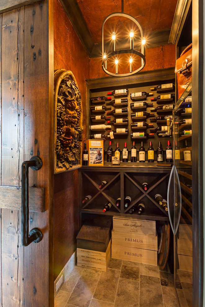 Wine cellar walls are paneled in Alder wood with a dark stain. The wine cellar lighting is Colwyn Chandelier from Currey and Co. Wine cellar paneleds walls. #Winecellar #walls #paneling #Alder #wood #darkstain wine-cellar Hendel Homes