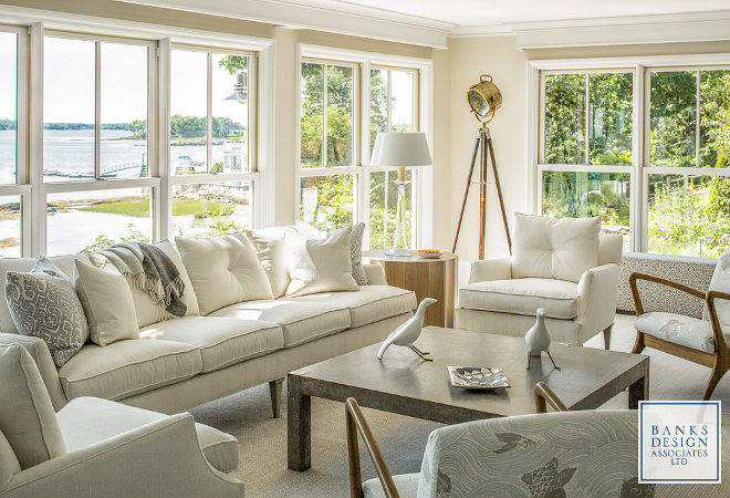 With floor-to-ceiling windows, the living room truly takes advantage of the stunning waterviews. The interior designer, Linda Banks, used clear glass lamps to not obscure the view and keep an airy feel. The sofa and chairs are covered in an indoor/outdoor canvaslike fabric. All furnishings in this home were sourced through Simply Home. Lighting: Currey & Company Glasshouse Table Lamp, white. Lamps flanking sofa: medium Trumpet Lamp by Barbara Cosgrove. Banks Design Associates, LTD & Simply Home