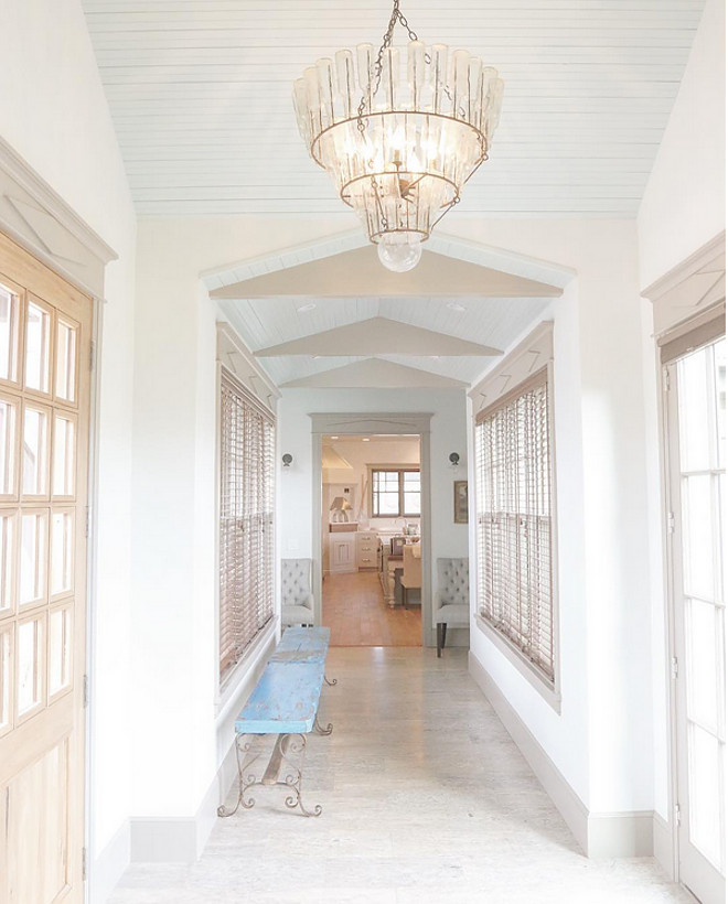 Blue ceiling paint color. The breezeway...going toward the family kitchen. Vintage soda bottle chandelier on pitched blue beadboard ceiling painted Sherwin Williams Copen Blue. Benches are from Anthropologie and sconces are from Restoration Hardware. blue beadboard ceiling painted Sherwin Williams Copen Blue #blue #beadboard #ceiling #blueceiling #paintcolor #SherwinWilliamsCopenBlue Home Bunch's Beautiful Homes of Instagram @artfulhomestead