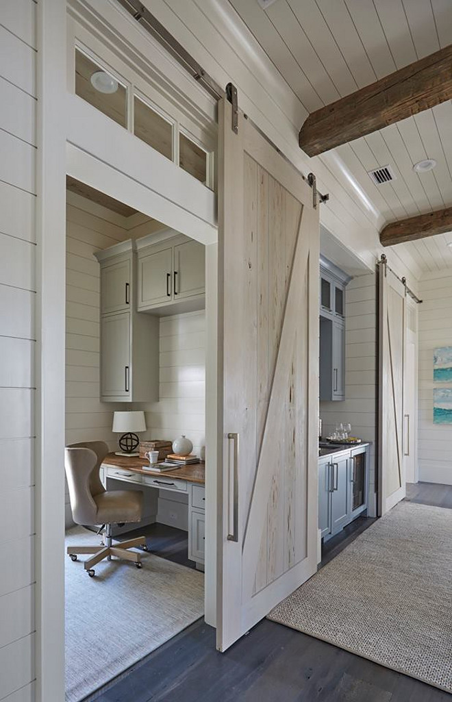 Whitewashed Barn Door. Whitewashed Barn Door Ideas. Office with Pecky Cypress Whitewashed Barn Door. A pecky cypress barn door opens to reveal a home office with light gray cabinets suspended over a gray built-in desk with wood top. Barn doors are painted in a custom whitewash stain. whitewash-barn-door #WhitewashedBarnDoor