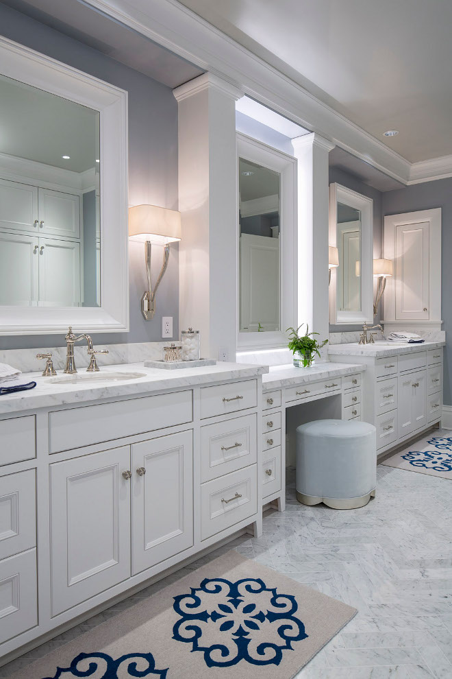 Bathroom make up vanity between sinks. Flooring is marble Bianco Carrara tile in a herringbone pattern. Bathroom make up vanity between cabinets. Bathroom make up vanity between his and hers vanity