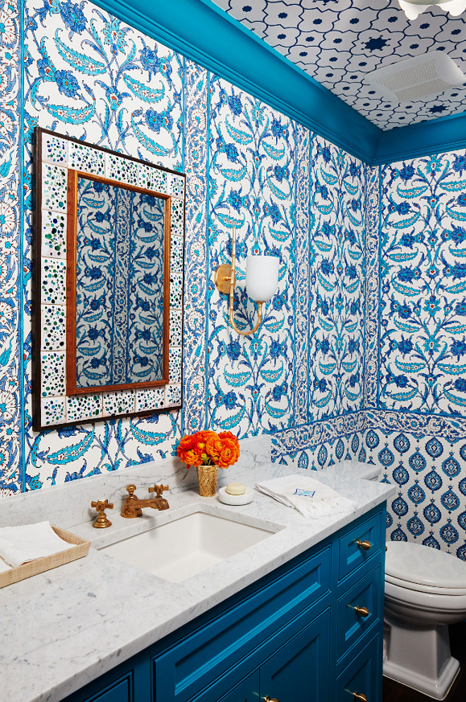 Bold Blue and White Powder Room. Bold Blue and White Powder Room Ideas. This is what the designer had to say about this space to House Beautiful: " This windowless powder room under the stairs feels hidden away from everything. Total excuse to go big!" The space is covered in three blue and white Schumacher wallpapers: Samovar and Topkapi on walls and Taj Trellis on the ceiling. Bold Blue and White Powder Room with blue and white wallpaper and blue vanity. Vanity and trim paint color is "Benjamin Moore 762 Pacific Palisades". #blueandwhite #powderroom #wallpaper #BenjaminMoore762PacificPalisades #BenjaminMoorePacificPalisades Andrew Howard Interior Design