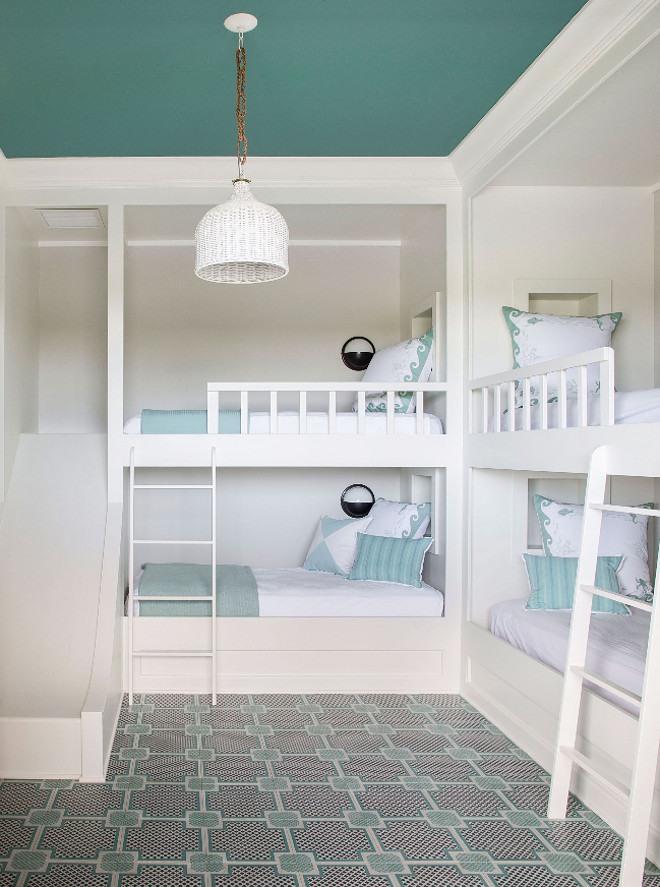 Bunk Room with Four Bunk Beds and Slide. Fantastic bunk room with four custom bunk beds and geometric flooring. The floor is engineered wood tile from Mirth Studio. One of the bunk beds feature a slide. #BunkRoom #FourBunkBeds #BunkBeds #BunkBedSlide Andrew Howard Interior Design