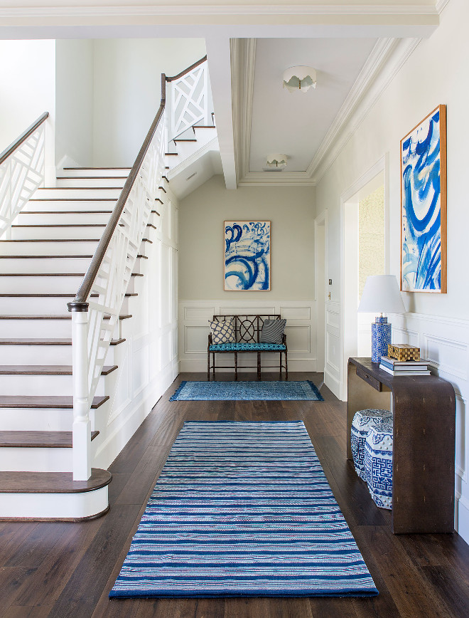 Foyer Wainscoting and Custom Staircase Railing. Beautiful foyer with blue and white decor, dark hardwood floors, wall wainscoting and custom staircase railing. #Foyer #Wainscoting #wallWainscoting #CustomStaircaseRailing #StaircaseRailing Andrew Howard Interior Design