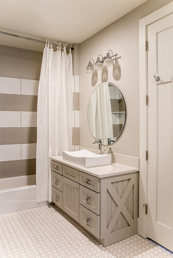 Greige bathroom with grey vanity, white quartz countertop and striped white and grey shower tile. #Greigebathroom #greyvanity #whitequartz #whitequartzcountertop #stripedtiles #whiteandgreytile #showertile Timberidge Custom Homes