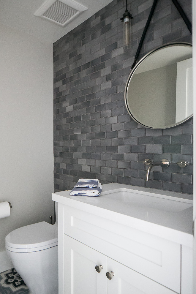 Grey Wall Tile. Bathroom grey accent wall tile. This beautiful powder room is made complete with a 4"x 4" charcoal grey Moroccan field tiled accent wall, custom black, grey and blue concrete decorative field tiled floor, mirror from Pottery Barn and Edison Glass Pendants from Restoration Hardware. #GreyWallTile #Bathroom #greyaccentwalltile Patterson Custom Homes