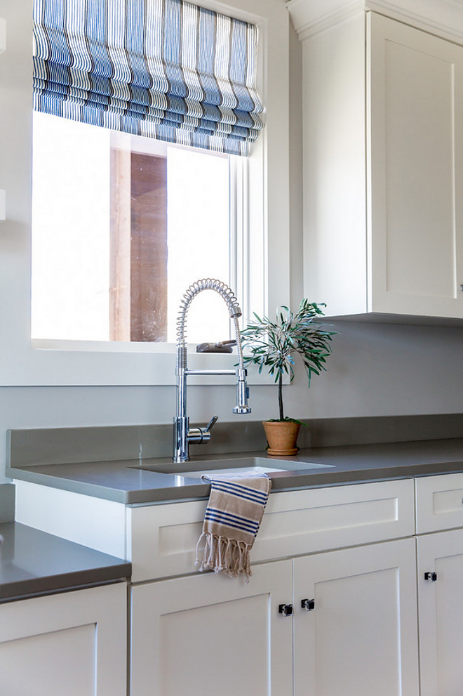 Laundry room with grey quartz countertop, industrial faucet and striped Roman shades. Laundry room. #Laundryroom #greyquartz #countertop #quartzcountertop #industrialfaucet #stripedRomanshades Timberidge Custom Homes