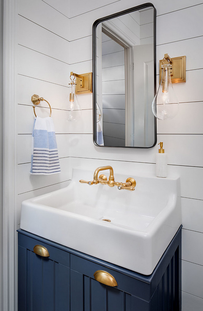 Navy Cabinet with shiplap paneling. Powder room features small navy vanity with matte brass hardware, wall mounted faucet, brass sconces and white shiplap wall paneling. #NavyCabinet #shiplappaneling #Powderroom #smallvanity #navyvanity #mattebrasshardware #mattehardware #wallmountedfaucet #brasssconces #whiteshiplap #shiplapwallpaneling #shiplap #paneling Tracy Lynn Studio