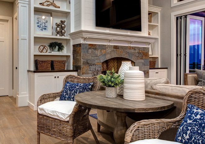 Round table with wicker chairs. Flanked by a pair of wicker chairs, this round table had the top customized to be placed behind the sofa. Open living room with round table with wicker chairs behind sofa. #Roundtable #wickerchairs #Openlivingroom Timberidge Custom Homes