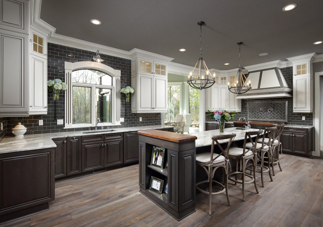 What a gorgeous modern farmhouse kitchen! The wall color here is Sherwin Williams Acier SW 9170. The cabinets are from Masterbrand, their Kitchen Craft Line. The top wall cabinets are their Alabaster color with Smoke Glaze and the bases are Thunder with Black Glaze. #ModernFarmhousekitchen #Farmhousekitchen Barrington Homes Inc.