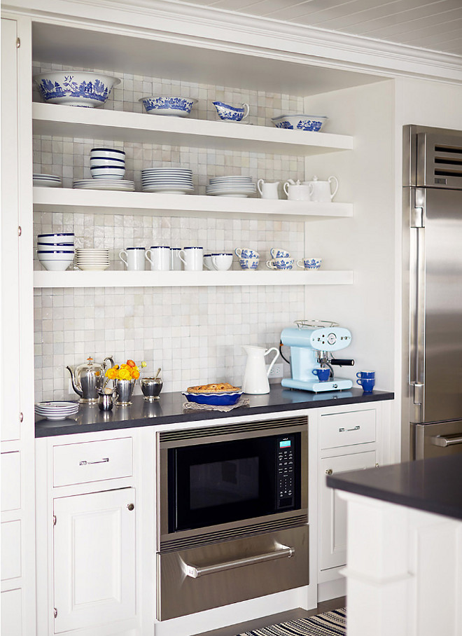 Decorator's White by Benjamin Moore. White kitchen with open shelves and cabinets painted in Decorator's White by Benjamin Moore. The open shelves display pretty blue-and-white dishware. Decorator's White by Benjamin Moore #DecoratorsWhitebyBenjaminMoore Andrew Howard Interior Design