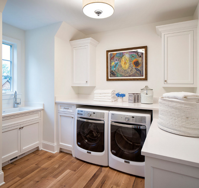 White laundry room painted in Benjamin Moore Chantilly Lace and with white quartz countertop #whitelaundryroom #whitelaundryroompaintcolor #BenjaminMooreChantillyLace Martha O'Hara Interiors. John Kraemer & Sons