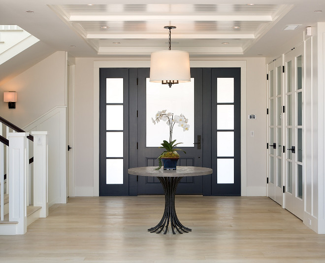 Crisp Foyer design with navy blue front door with frosted glass, beadboard ceiling and white oak hardwood flooring #Foyerdesign #navyblue #frontdoor #frostedglass #whiteoak #hardwoodflooring Christian Rice Architects, Inc