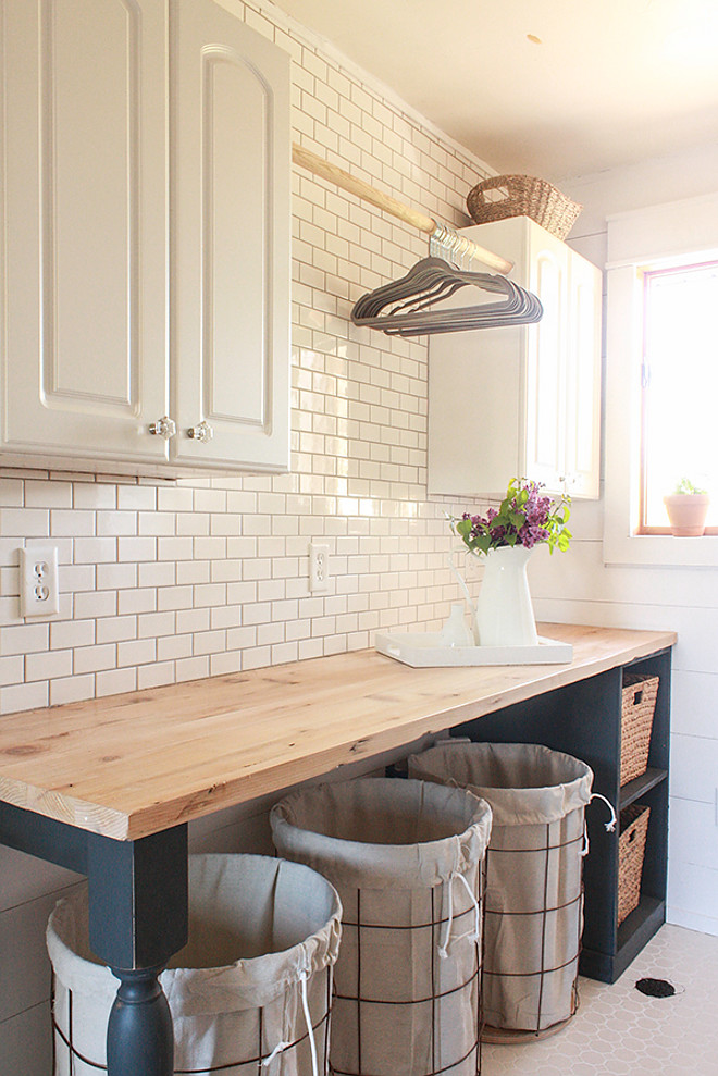 Farmhouse Laundry Room. Gorgeous farmhouse laundry room with diy folding table with butler's block countertop, diy shiplap walls and white subway tile backsplash. Farmhouse Laundry Room. Farmhouse Laundry Room Design. Farmhouse Laundry Room. Farmhouse Laundry Room #FarmhouseLaundryRoom #Farmhouse #LaundryRoom Twelve On Main