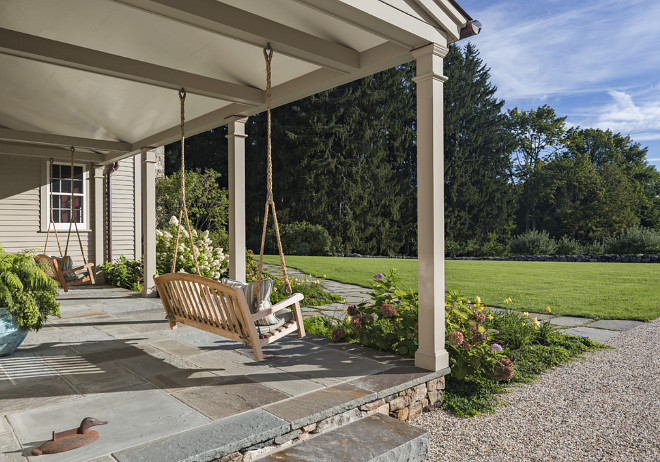 Front Porch with two swings, The entrance porch is paved in bluestone and features twin swings #porchswing #porch #swing