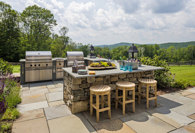 Outdoor kitchen The outdoor kitchen features fieldstone walls with bluestone counters and copper lanterns #Outdoorkitchen Haver & Skolnick LLC Architects