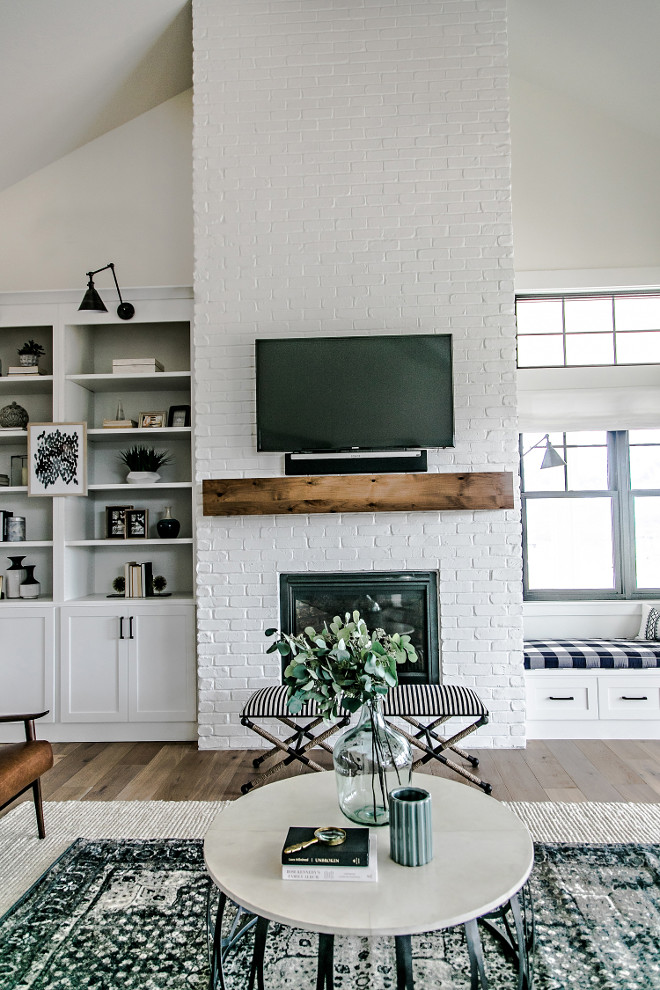 Farmhouse Brick Fireplace. The painted brick fireplace is the focal point of the family room. Warmth was introduced into the space with the addition of a custom made white oak mantel. The mantel was given a custom stain, which compliments the other wood tones in the home. #FixerUppper #MagnoliaMarket #Farmhousestyle Sita Montgomery Interiors