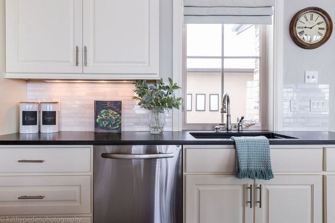 Kitchen. This kitchen is timeless with white cabinetry, dark quartz countertops, marble backsplash and brushed nickel hardware. Paint color is Revere Pewter by Benjamin Moore. Kitchen #kitchen #whitecabinetry #darkquartzcountertops #quartzcountertops #marblebacksplash #backsplash #brushednickelhardware. #Paintcolor #ReverePewterbyBenjaminMoore Restyle Design, LLC.